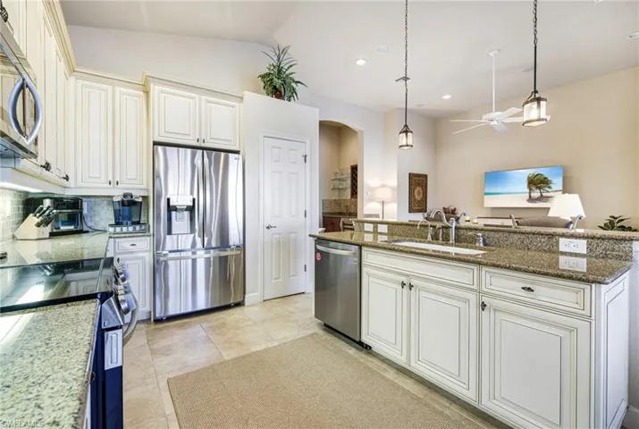 Kitchen featuring new stainless steel appliances, decorative light fixtures, Granite countertops, Wood Cabinets and Enameled sink