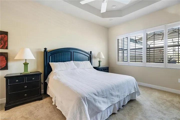 Bedroom with Plantation Shutters, Tray ceiling and door that leads to Lanai
