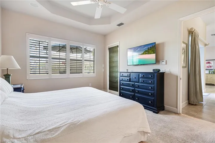 Bedroom with Plantation Shutters, Tray ceiling and door that leads to Lanai