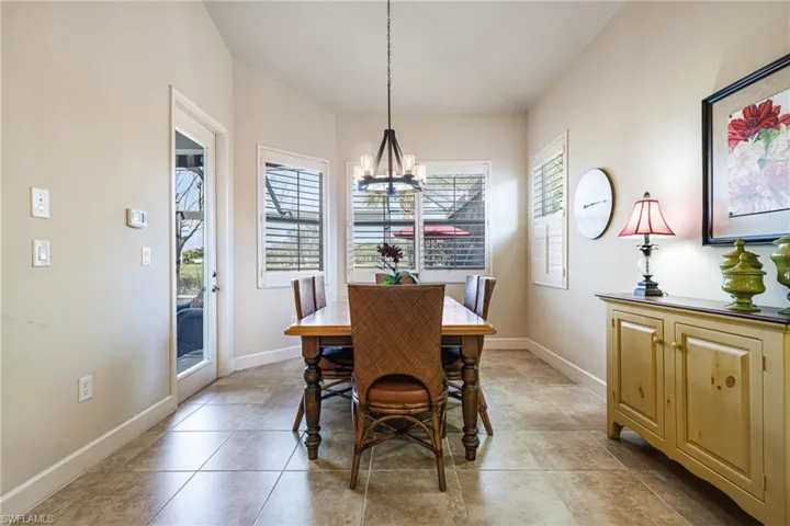 Dining area with chandelier, Plantation Shutters and door to Lanai