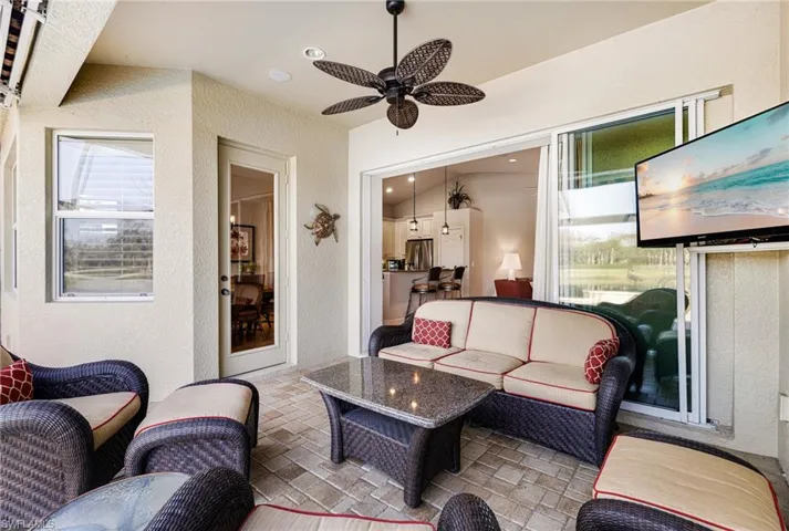 View of patio with an outdoor living space  with wall mounted TV and ceiling fan
