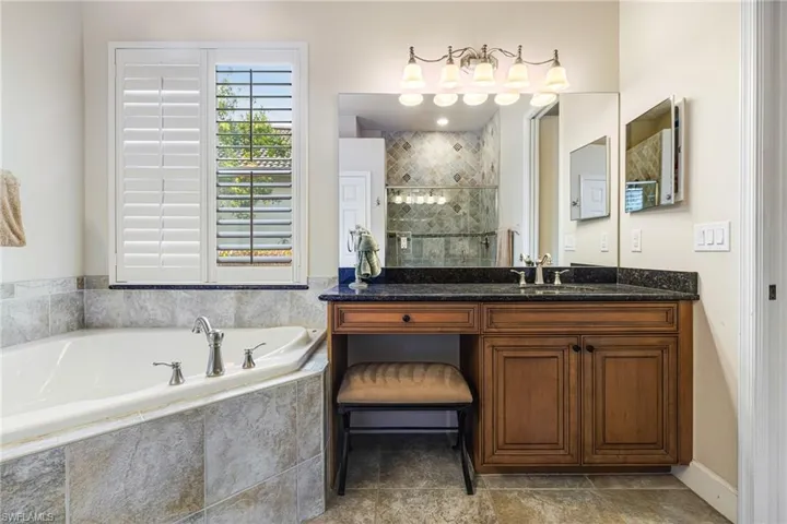 Bathroom with Dual Wooden Vanities with Granite counters, roll out cabinet shelves, a wealth of natural light with Plantation Shutters