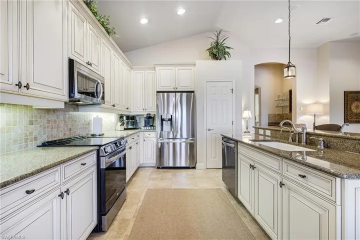 Kitchen featuring new stainless steel appliances, decorative light fixtures, Granite countertops, Wood Cabinets and Enameled sink