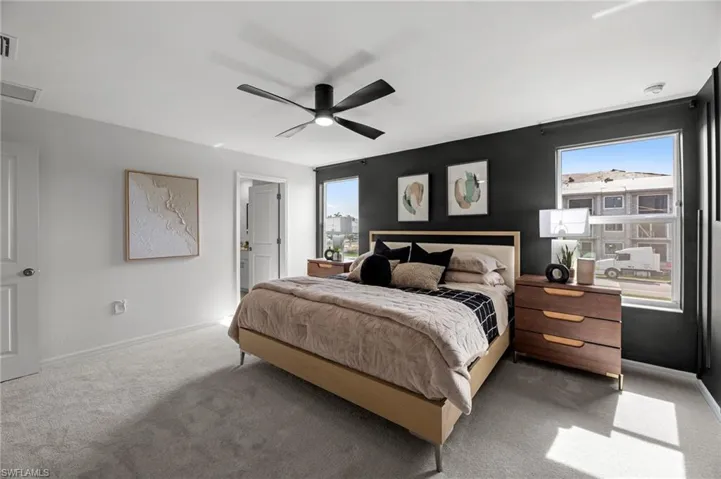 Carpeted bedroom featuring visible vents, baseboards, and a ceiling fan