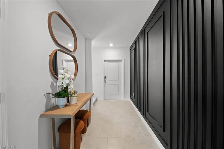 Corridor with light tile patterned floors, baseboards, and recessed lighting