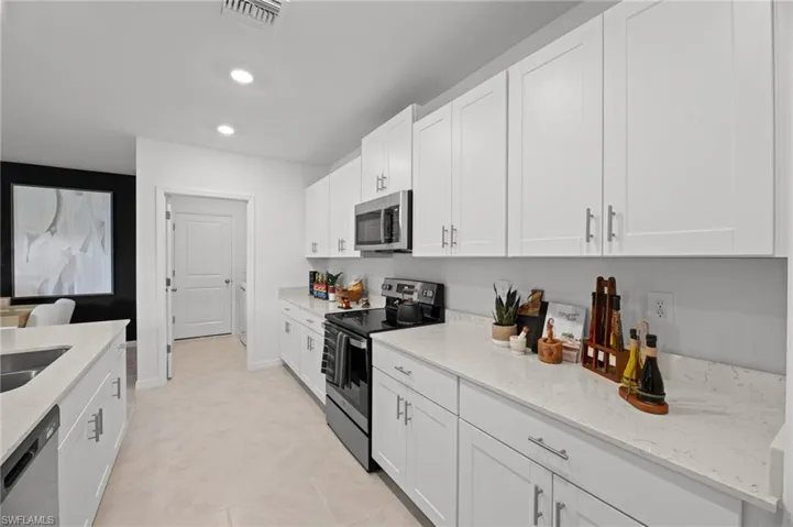 Kitchen featuring visible vents, white cabinets, recessed lighting, and stainless steel appliances