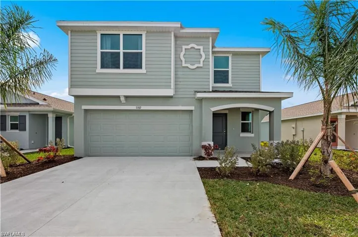 Traditional-style home featuring an attached garage, concrete driveway, and stucco siding