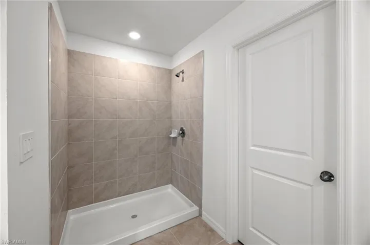 Bathroom with tiled shower and tile patterned flooring