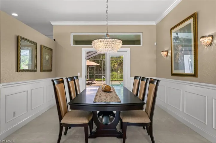 Elegant formal dining room accented by custom millwork, crown molding, and a contemporary chandelier.