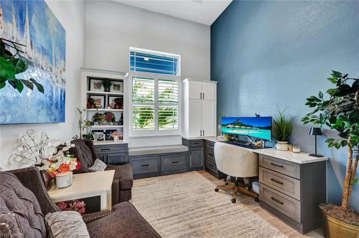 Home office with a textured wall and light wood-style flooring