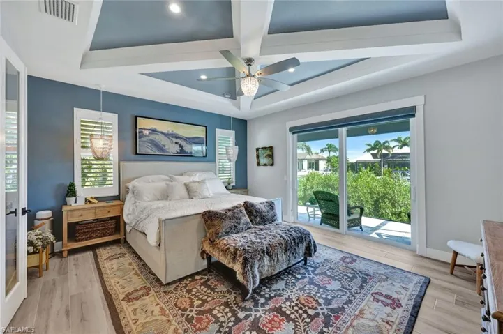 Bedroom with access to exterior, ceiling fan, beam ceiling, coffered ceiling, and light wood-type flooring