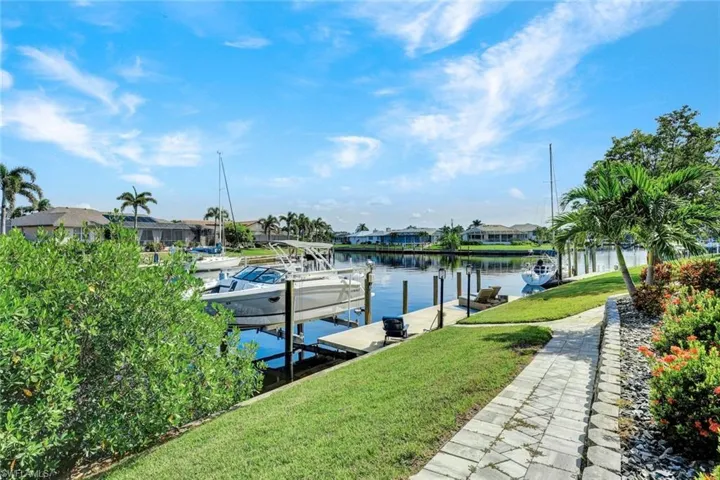 Dock area featuring a lawn, a water view, a residential view, and boat lift