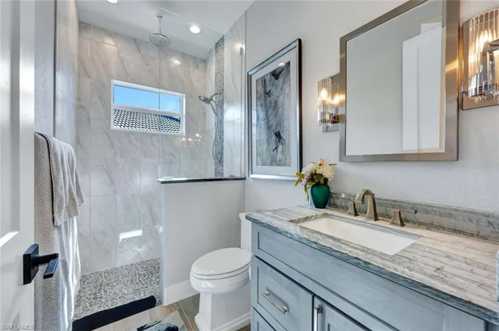 Bathroom featuring vanity, walk in shower, and light wood finished floors