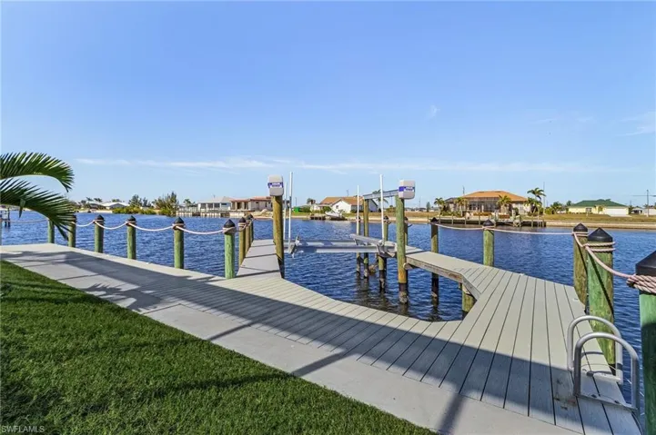 View of dock featuring a water view and a lawn