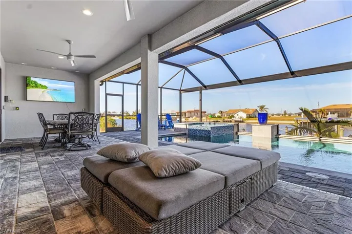 View of patio / terrace featuring ceiling fan, a pool with hot tub, and glass enclosure