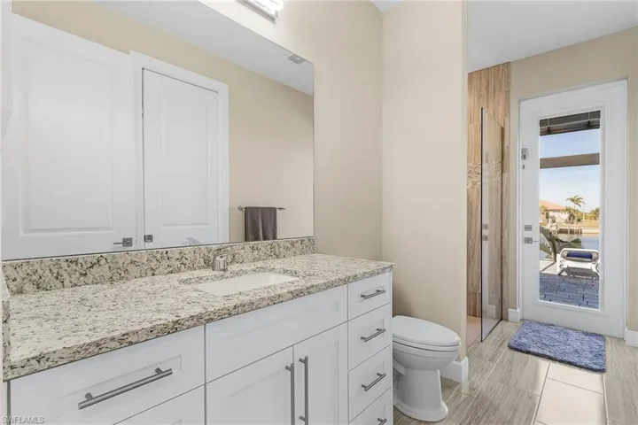 Bathroom with vanity, a shower, and toilet