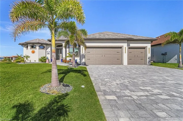 View of front of house with a garage and a front lawn