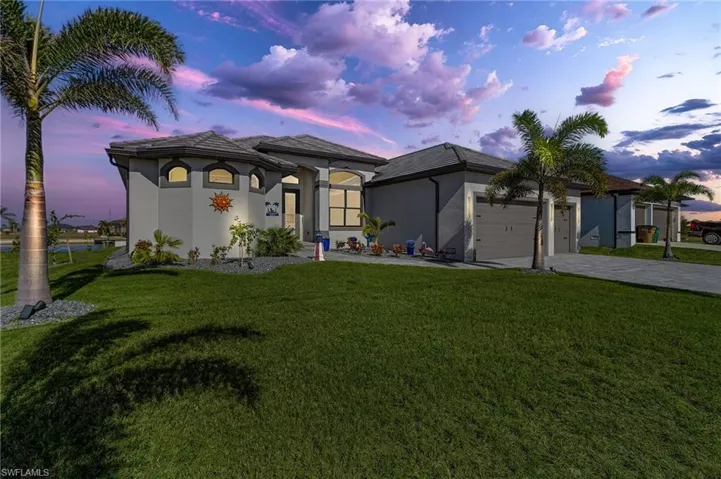 View of front of home featuring a yard and a garage