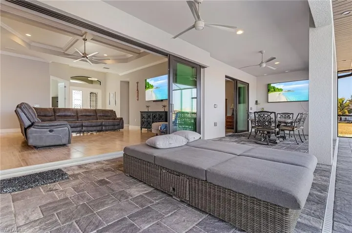 Bedroom featuring coffered ceiling, multiple windows, ornamental molding, and access to outside