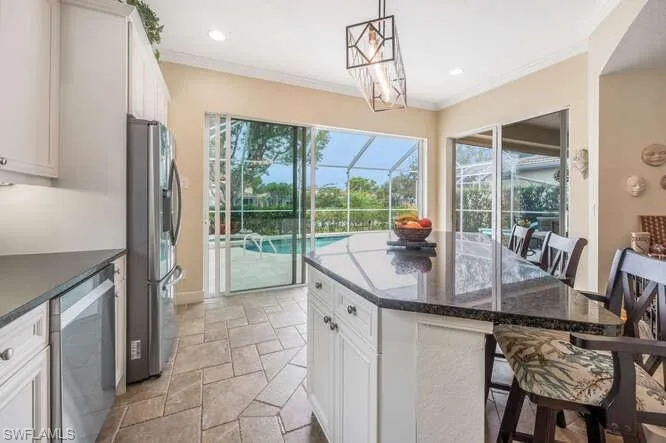 Kitchen with a kitchen island, white cabinets, a breakfast bar, and appliances with stainless steel finishes
