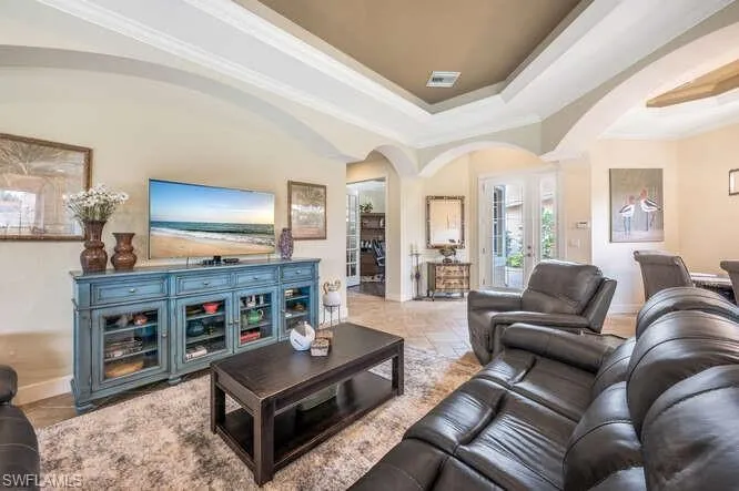 Living room with a tray ceiling and ornamental molding