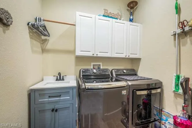 Laundry room with sink, cabinets, and washer and dryer