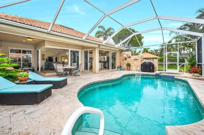 View of pool with a patio and glass enclosure