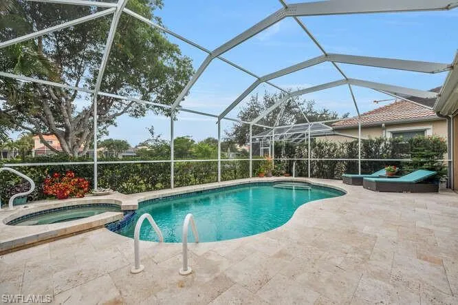 View of pool with an in ground hot tub, a patio area, and a lanai