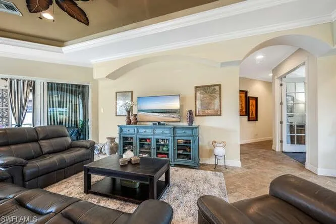 Living room with a raised ceiling and ornamental molding