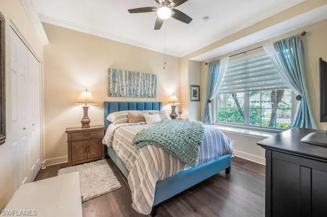 Bedroom featuring dark wood-type flooring, a closet, ceiling fan, and ornamental molding