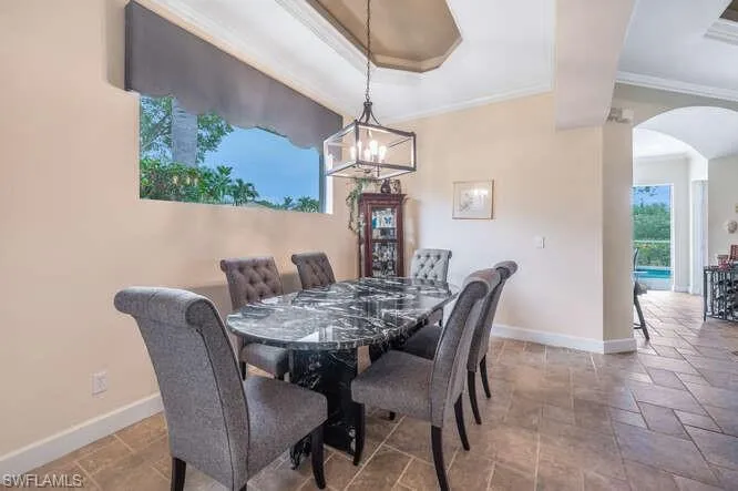 Dining space with crown molding and an inviting chandelier