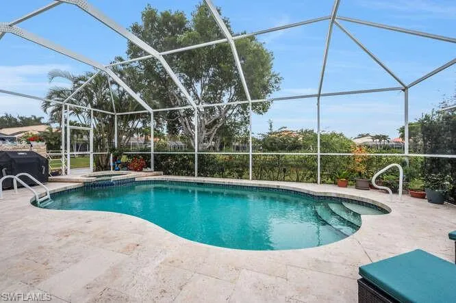 View of pool featuring glass enclosure, an in ground hot tub, and a patio