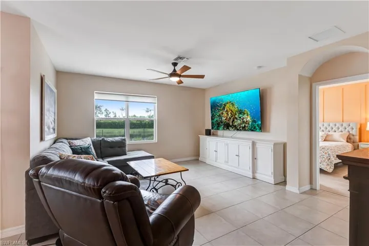 Living room featuring ceiling fan and light tile patterned floors