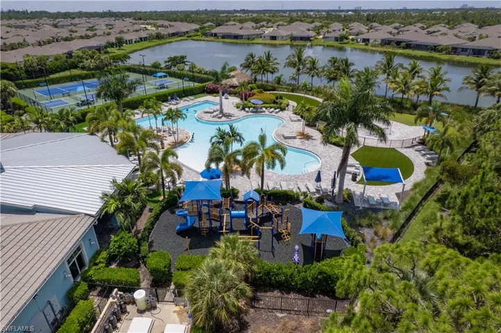Aerial perspective of suburban area with a pool area and a large body of water