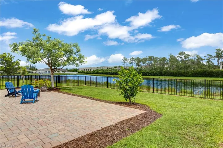Fenced backyard featuring a patio area and a water view