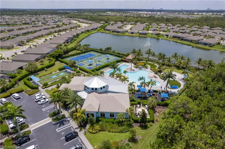 Aerial perspective of suburban area featuring a pool and a large body of water