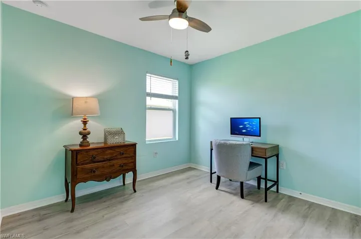 Office space with wood finished floors and a ceiling fan