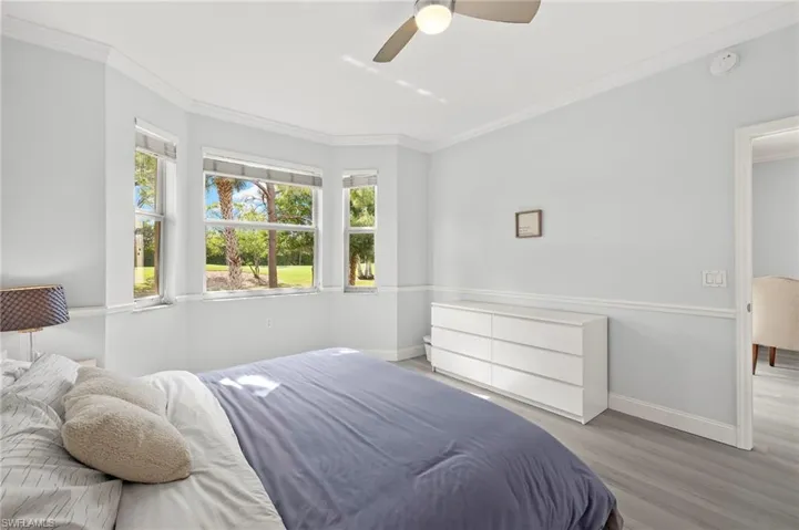 Bedroom featuring crown molding, baseboards, and wood finished floors