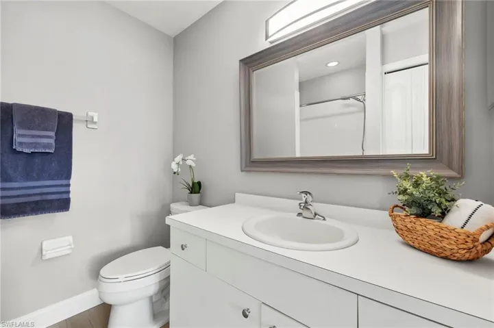 Bathroom featuring vanity, baseboards, and toilet