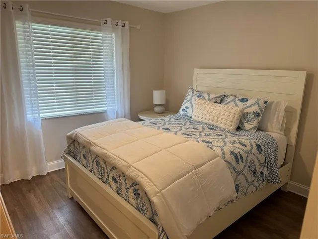 Bedroom with dark wood-type flooring and multiple windows
