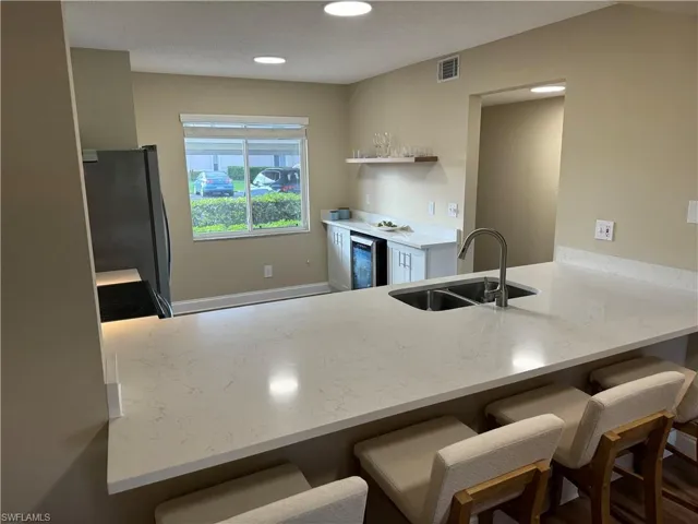 Eat in bar overlooking kitchen that includes wine cooler.