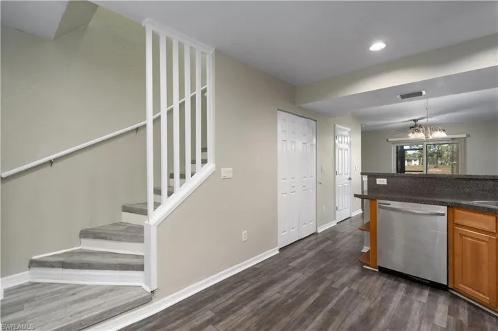Kitchen featuring dark hardwood / wood-style flooring, dishwasher, and a notable chandelier