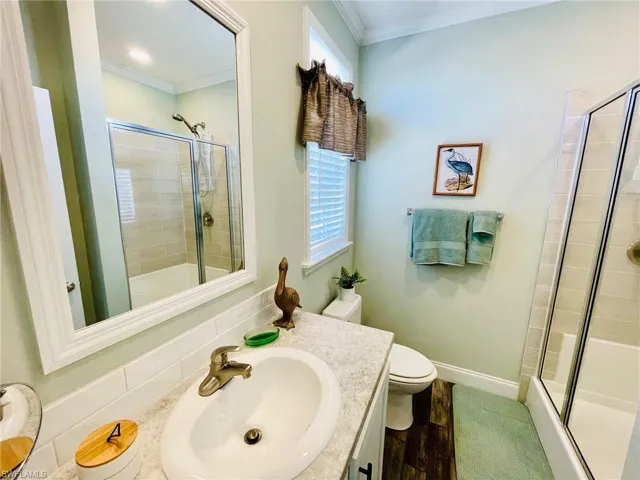 Bathroom featuring vanity, toilet, Shower and crown molding