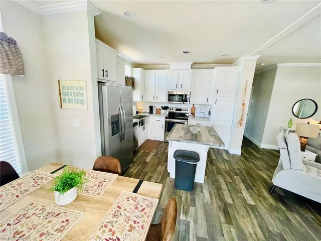 Kitchen with white cabinetry, stainless steel appliances and a  center island