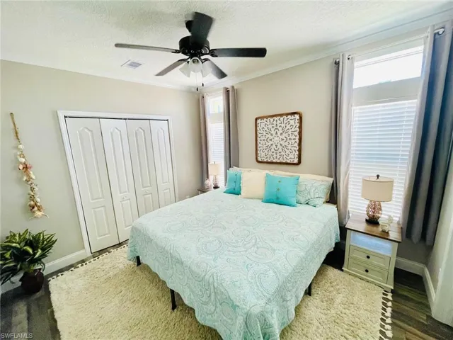 Bedroom featuring multiple windows, ceiling fan, and a closet.