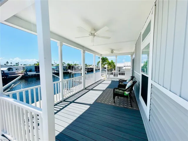 Deck featuring a boat dock, a water view, and ceiling fan