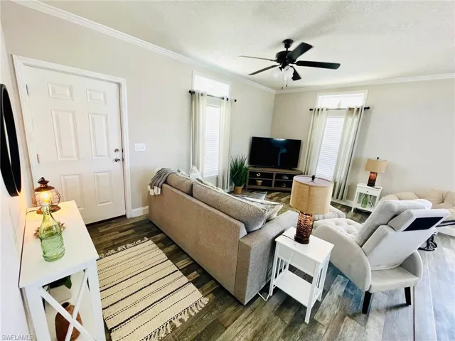 Living room featuring crown molding, and ceiling fan
