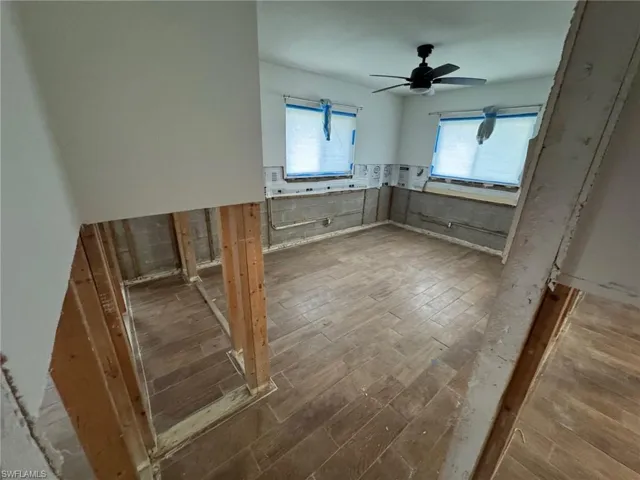 Spare room with wood-type flooring, ceiling fan, and a healthy amount of sunlight