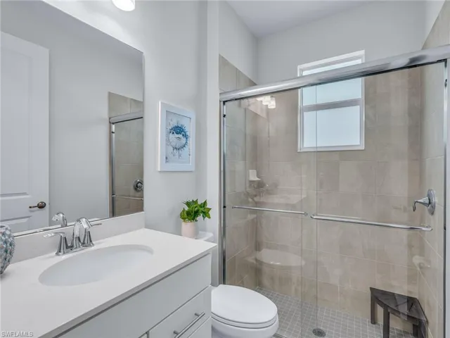 Bathroom featuring a large vanity with an undermount sink, a quartz-finish countertop, and a chrome faucet