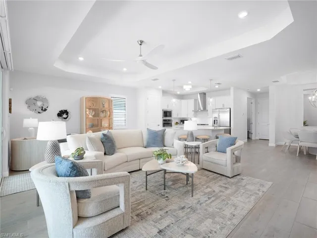 Open-concept living area featuring tray ceilings